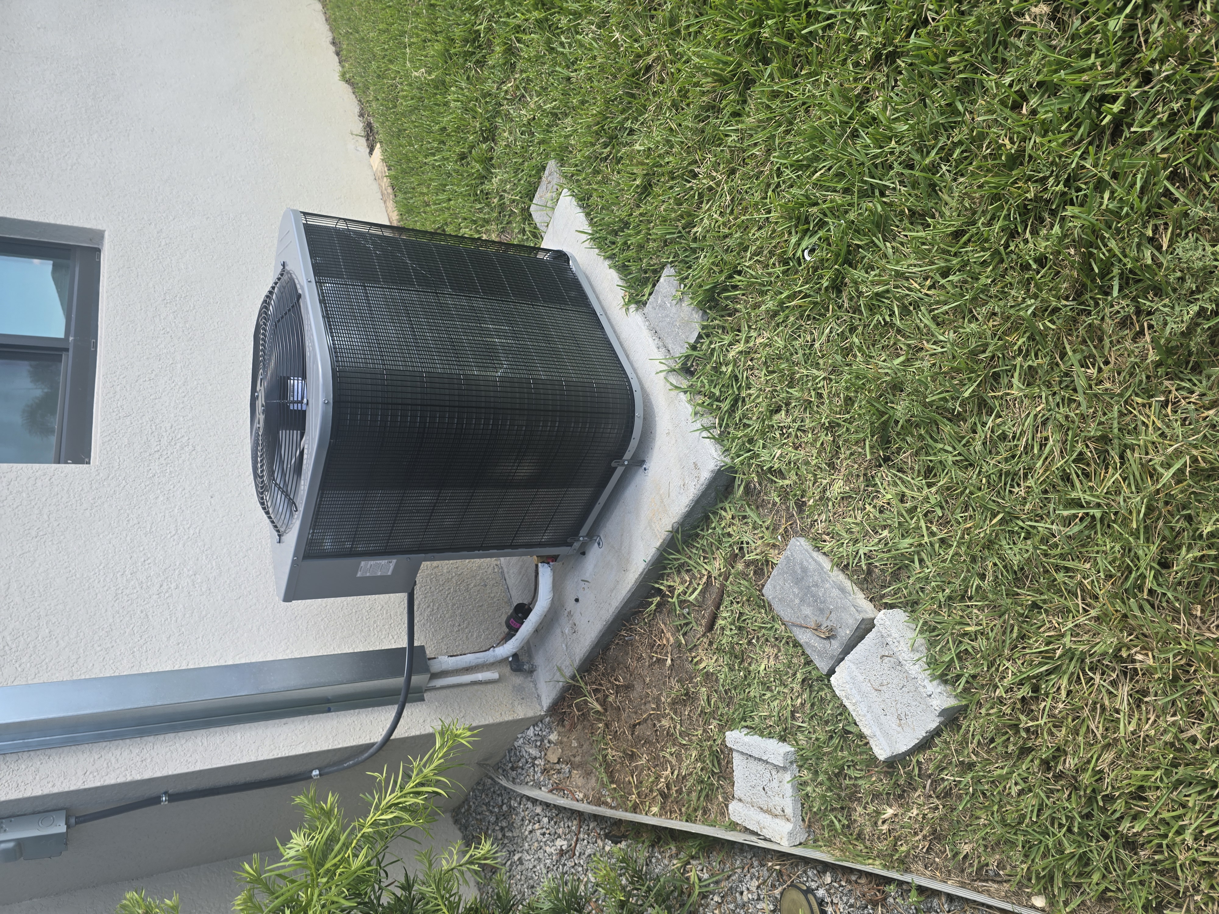Outdoor AC condenser installed on pad